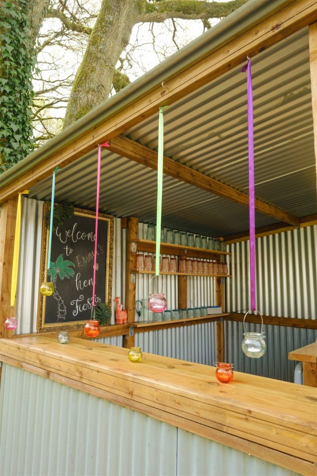 Exterior photo in Tropic hen camp, showing outdoor kitchen with colourful, hanging glass candle holders