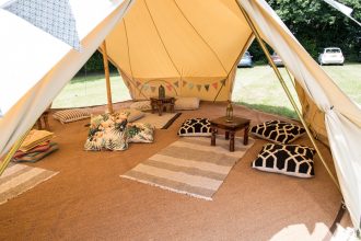 7m chill out bell tent with tropical cushions and wool rugs