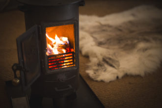 Log burner inside Beautiful Bells glamping wedding tent