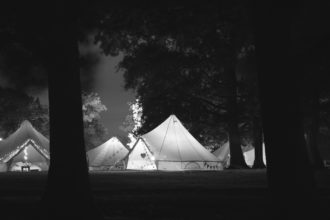 Bell tents viewed at night with the tents lit up