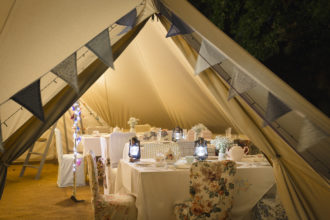 Bell tent set up with tables and chairs for a vintage tea party