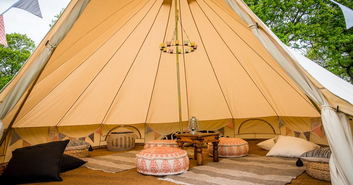 7m chill out bell tent with tea-light chandelier and floor cushions. Chill out bell tent hire West Sussex.