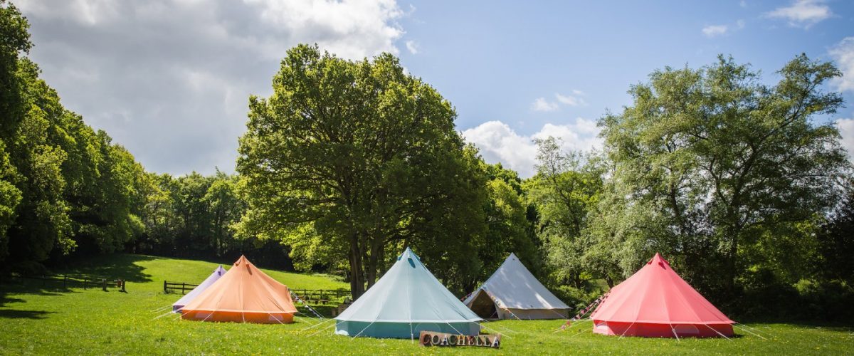 Coachella Hen Camp 2018 Exterior picture showing coloured bell tents for Coachella (now Tropic) hen camp area. Luxury glamping for hen parties. See more in our hen camp gallery