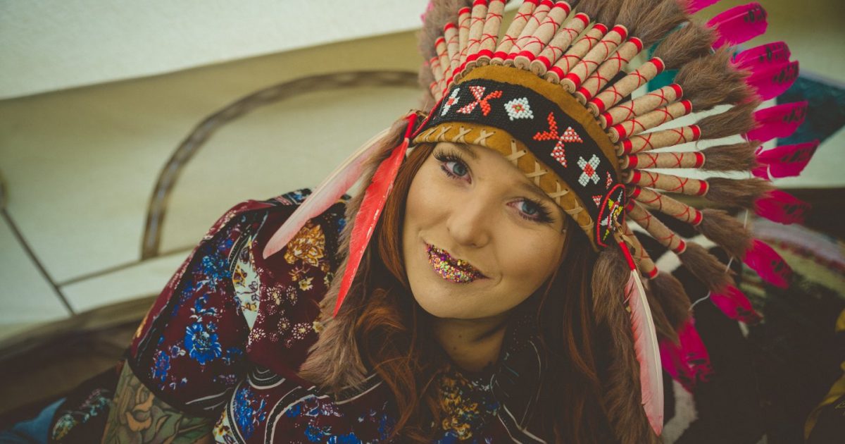 Glamping Hen Party Tips. Hen Party Bell Tent Hire. Hen in feathered headdress. Tips for planning a glamping hen party