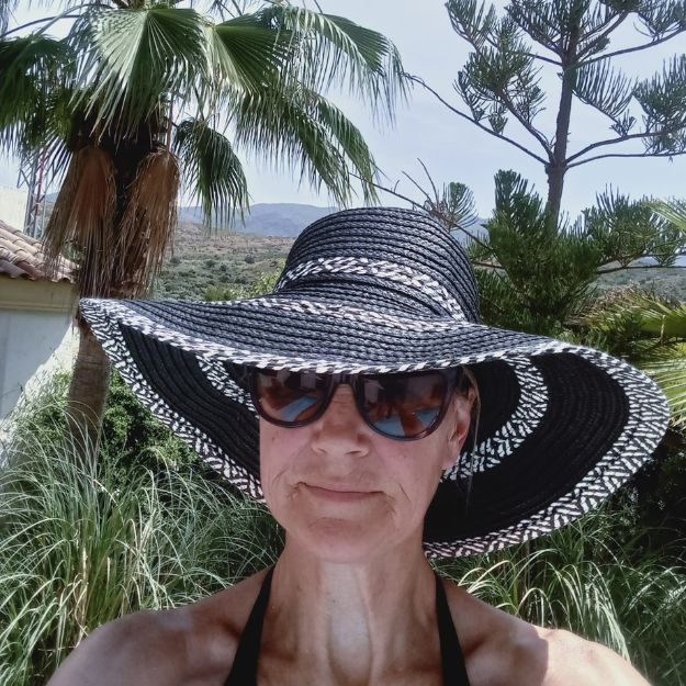Amanda on holiday wearing a black rimed hat