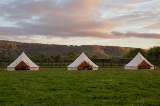 3 cream bell tents set up for glamping holidays